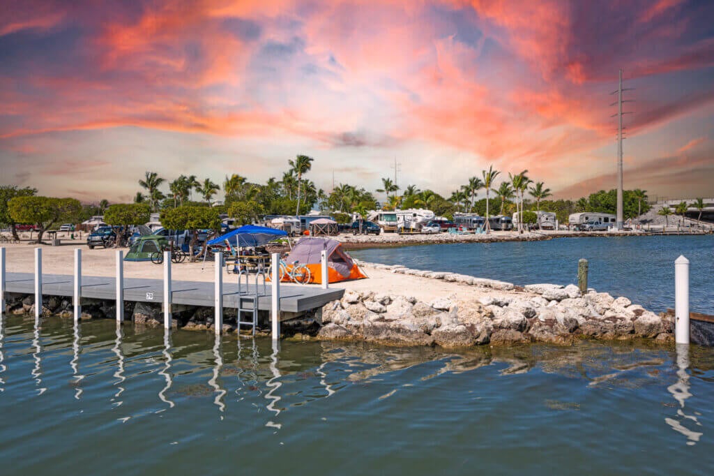 An orange tent at a rustic RV campground site on the beach at Big Pine Key RV Park in Florida.