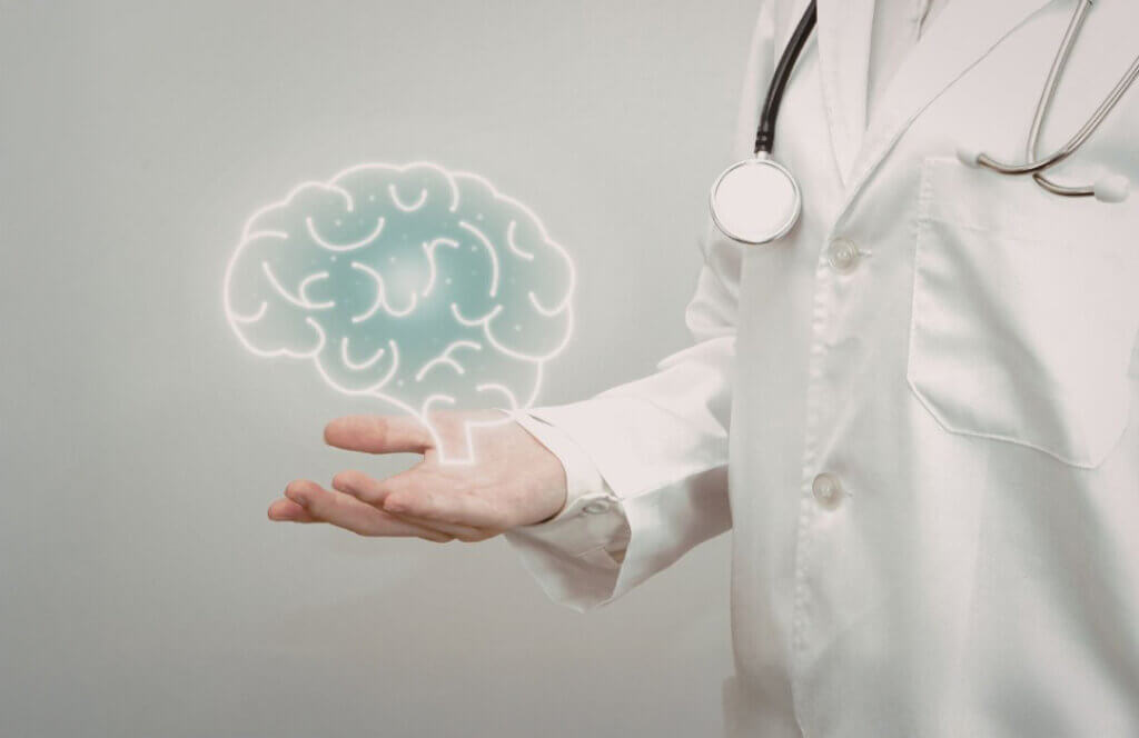 A person in a white lab coat holding a glowing outline of a brain in their palm.