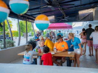 Burger_Cookout_Big_Pine_Key_RV_Florida A group of people at picnic tables eating burgers during their burger cookout at Big Pine Key RV Park in Florida.