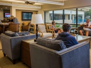 Group of people sitting down in chairs at the clubhouse in Camelot Lakes Village.