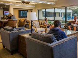 Group of people sitting down in chairs at the clubhouse in Camelot Lakes Village.