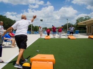Residents playing cornhole at Camelot Lakes Village.