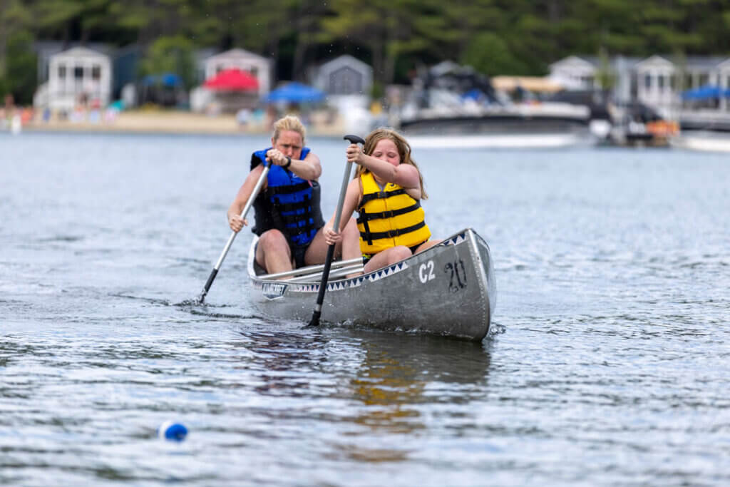 Mother and daughter paddling during a canoe race across Maple Cove on Sebago Lake.