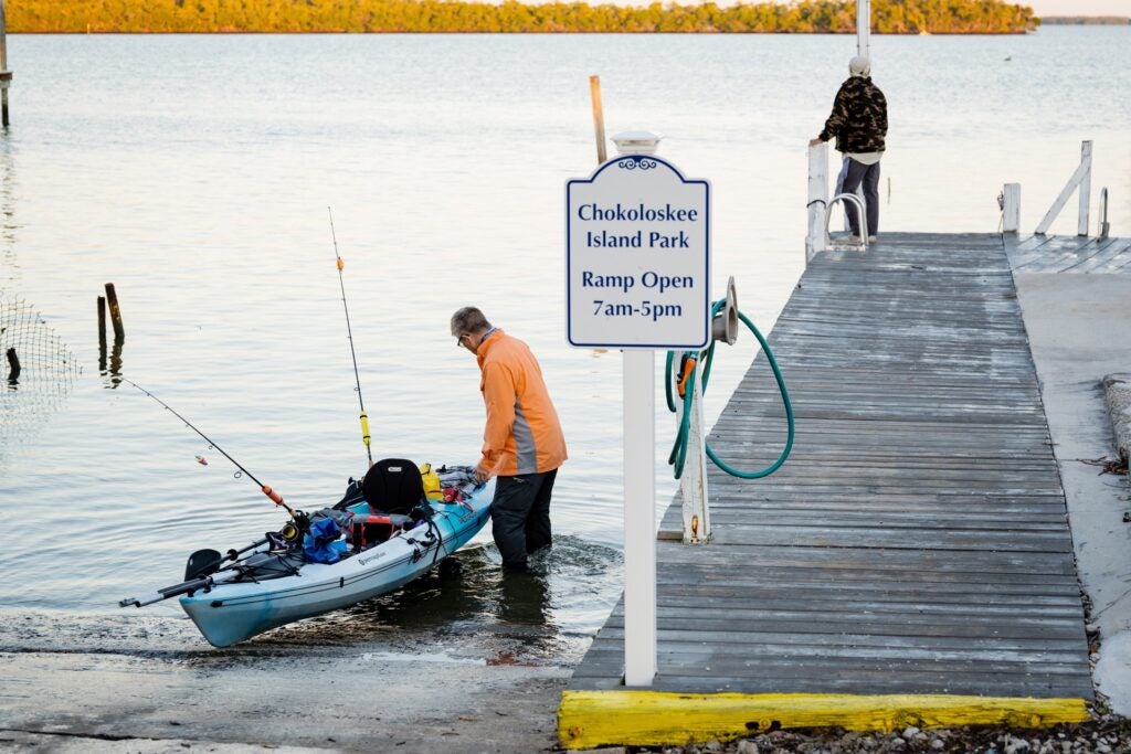 Man taking kayak on water at Chokoloskee Island Resort