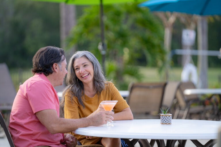 couple enjoying cocktails on patio at cypress lakes