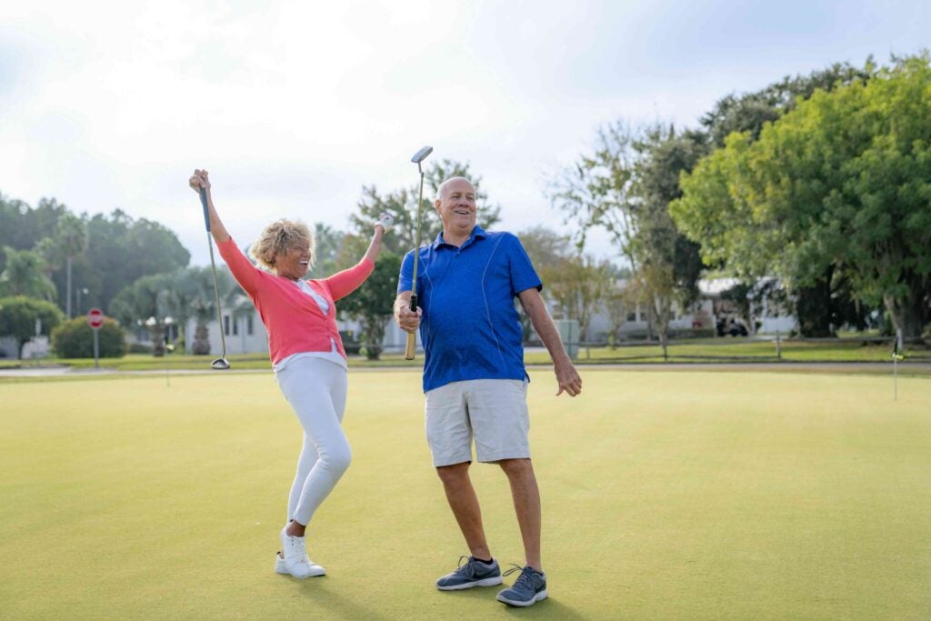 Couple playing golf and cheering