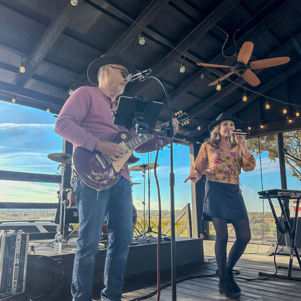 Live music duo Dennie and the Jets perform on stage.