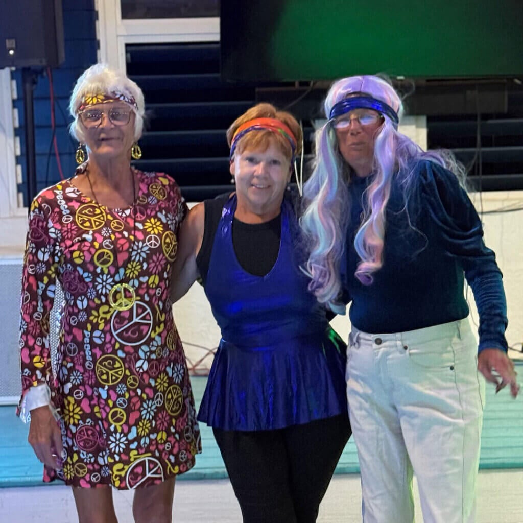 Three people dressed in 70s disco costumes at Big Pine Key Rv Park in Florida