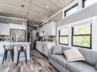Kitchen and living room inside the model cottage at Point Sebago. The photo shows an park model created by Elevation.