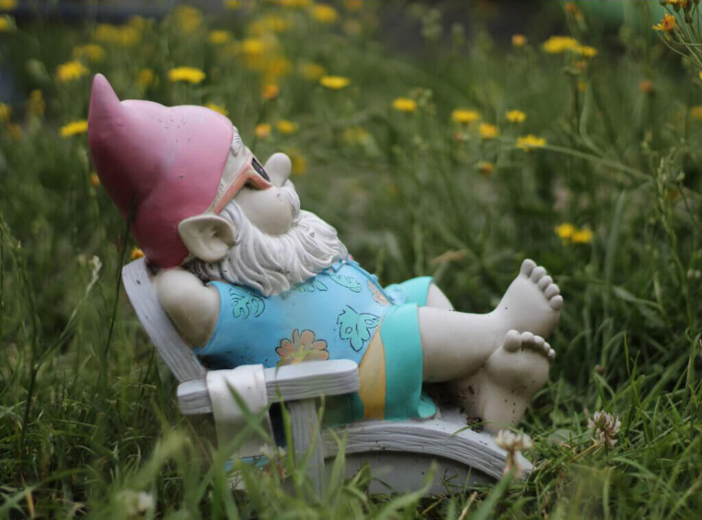 Summertime Garden gnome in a field wearing a Hawaiian shirt