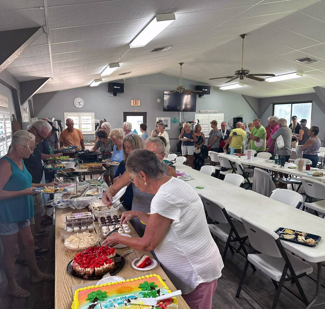 Holiday RV guests lined up and dishing out food at the community potluck