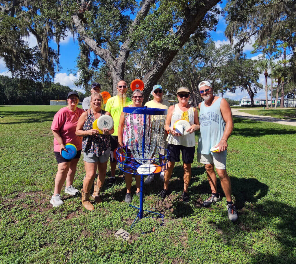Guests standing together holding discs at new disc golf course at Holiday