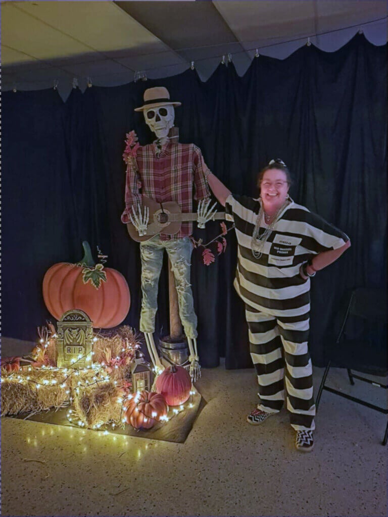 Guest at Holiday in costume with skeleton halloween decor at community dance