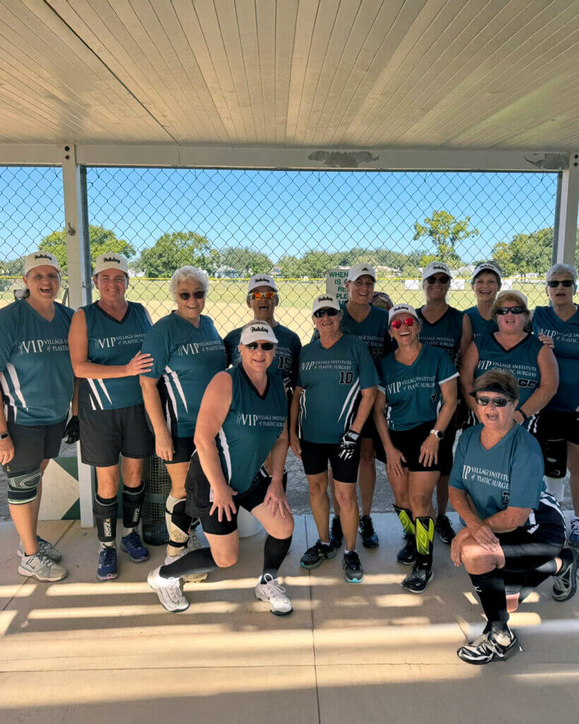 Ladies Holiday RV Park Softball team take a photo in the dugout