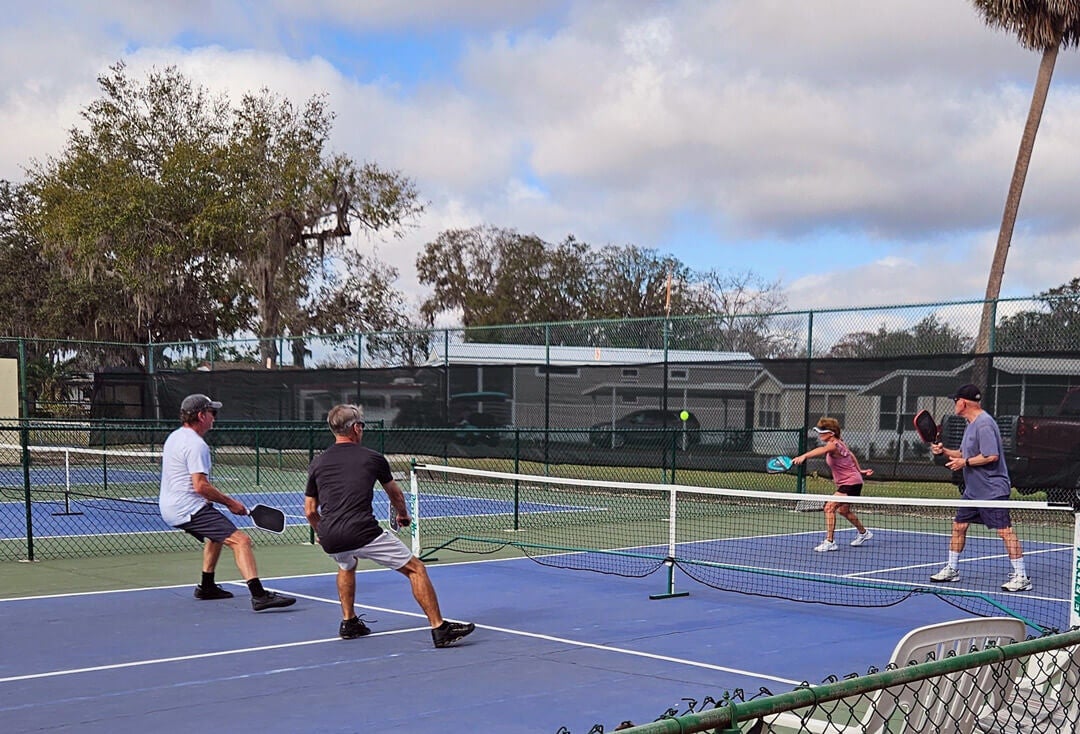 four guests playing pickleball at the Holiday RV outdoor sports courts