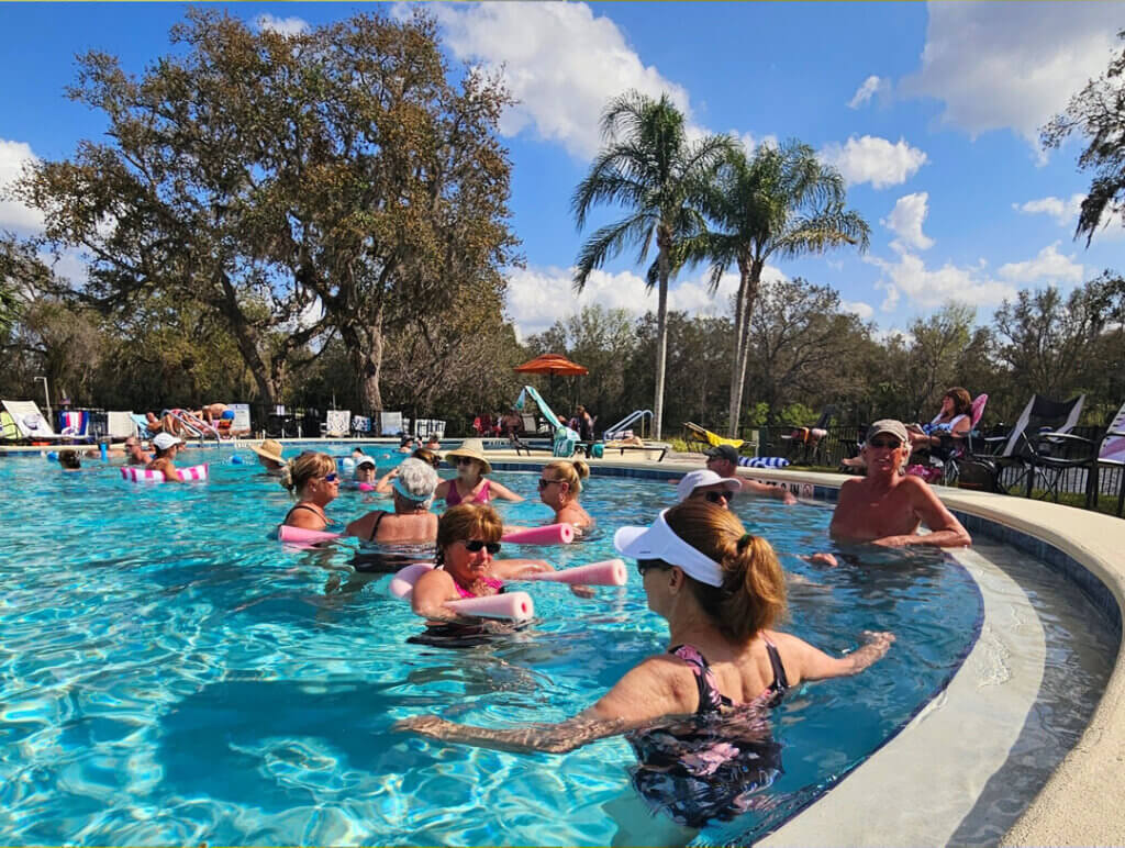 Residents at Holiday RV Park in Leesburg, Florida gather in the pool on a sunny afternoon.