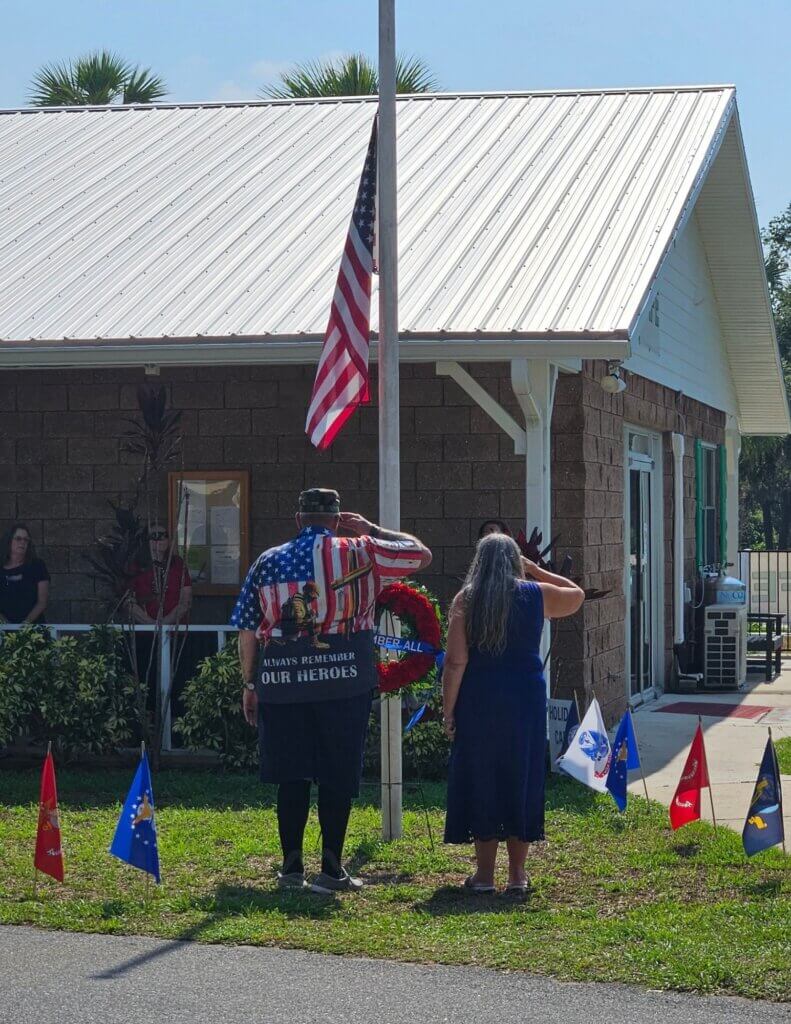Residents in red white and blue paying tribute to American Veterans at the flag pole