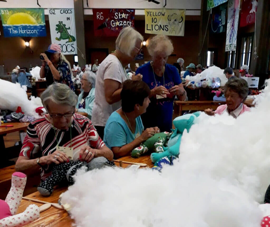 Ladies from Helping Hands Club at Holiday RV Park attend Camp Boggy Creek to stuff teddy bears for the children with illnesses