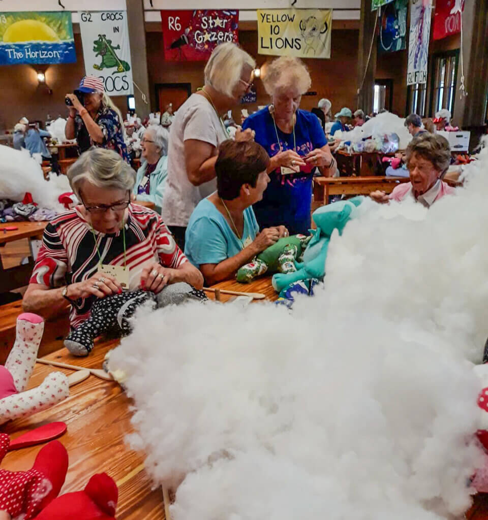 Ladies from Helping Hands Club at Holiday RV Park attend Camp Boggy Creek to stuff teddy bears for the children with illnesses