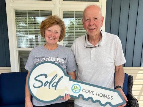 New homeowners showing off their big key at Rolling Greens Village in Ocala, Florida.