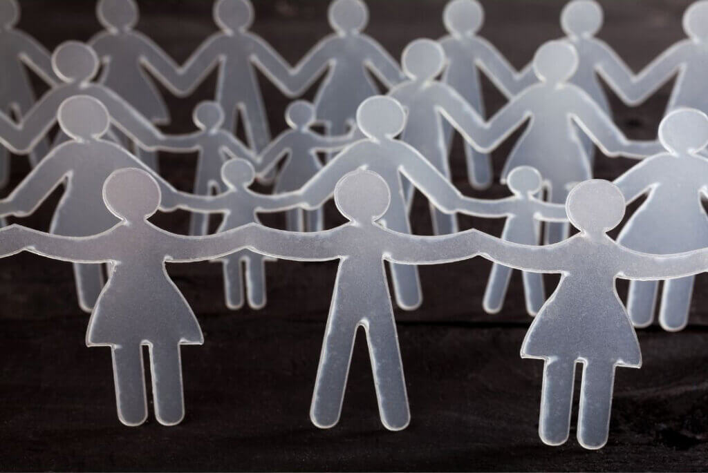 A chain of translucent, simplified human figures holding hands against a dark background.
