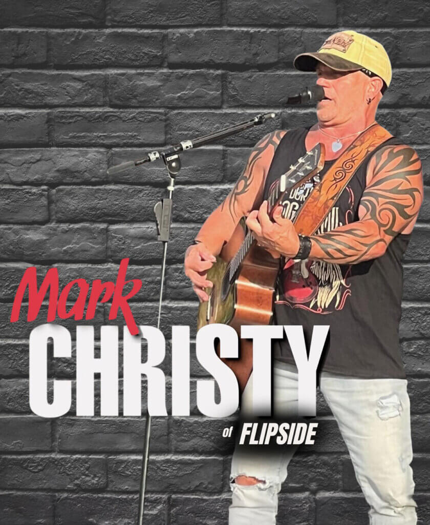 Singer Mark Christy at the microphone singing with his guitar