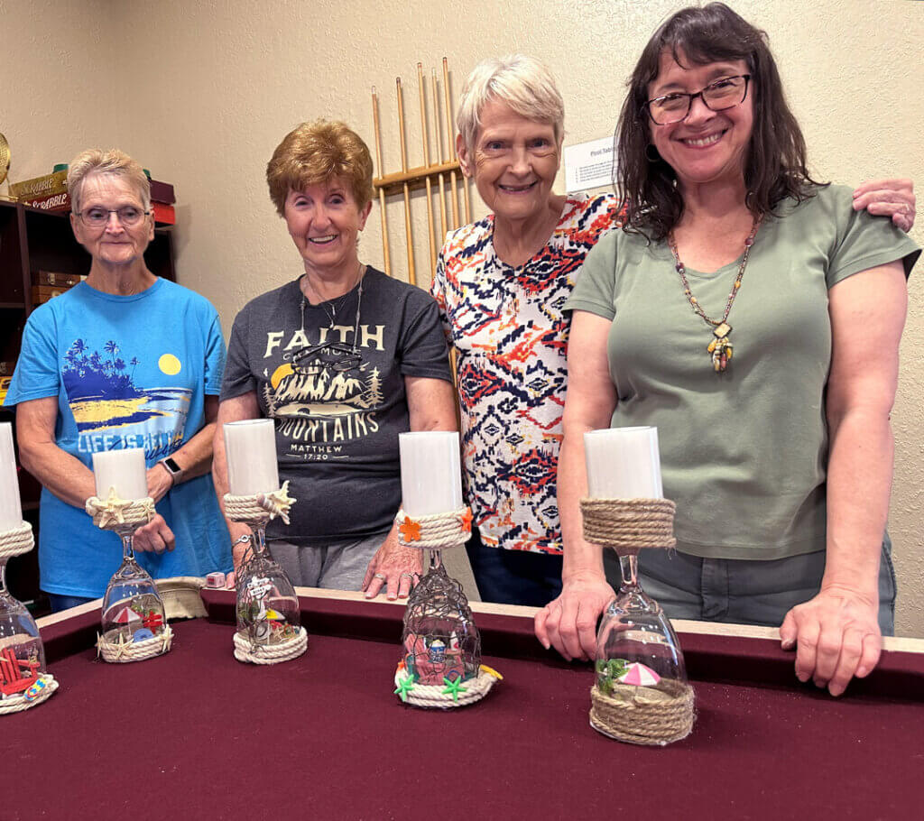 residents smile with their candle craft