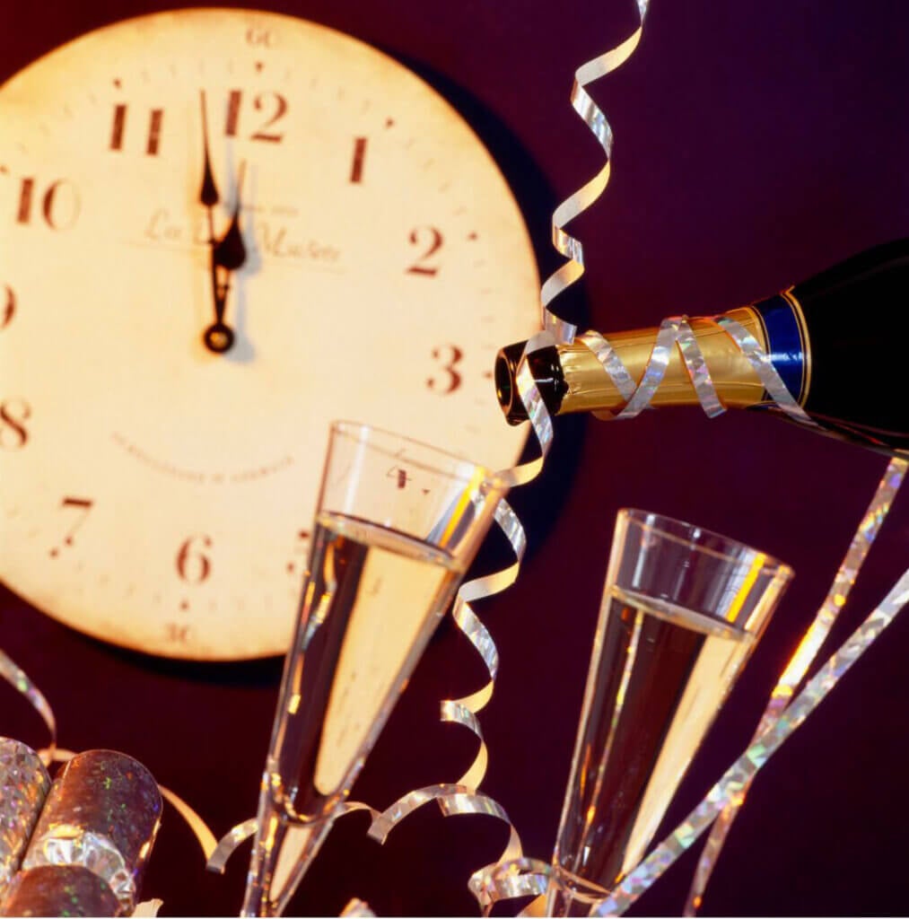 Clock hitting 12:00 and champagne- New Years Eve Stock Photo