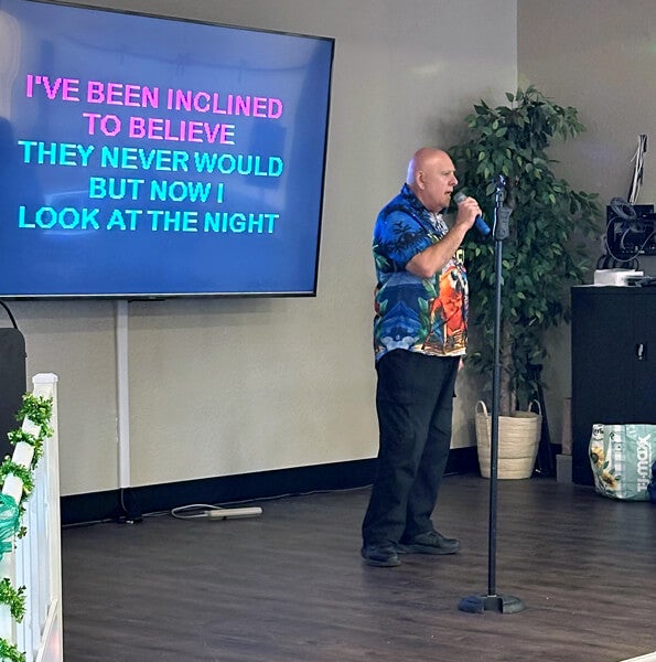 55+ resident on The Meadows stage in the clubhouse singing Karaoke