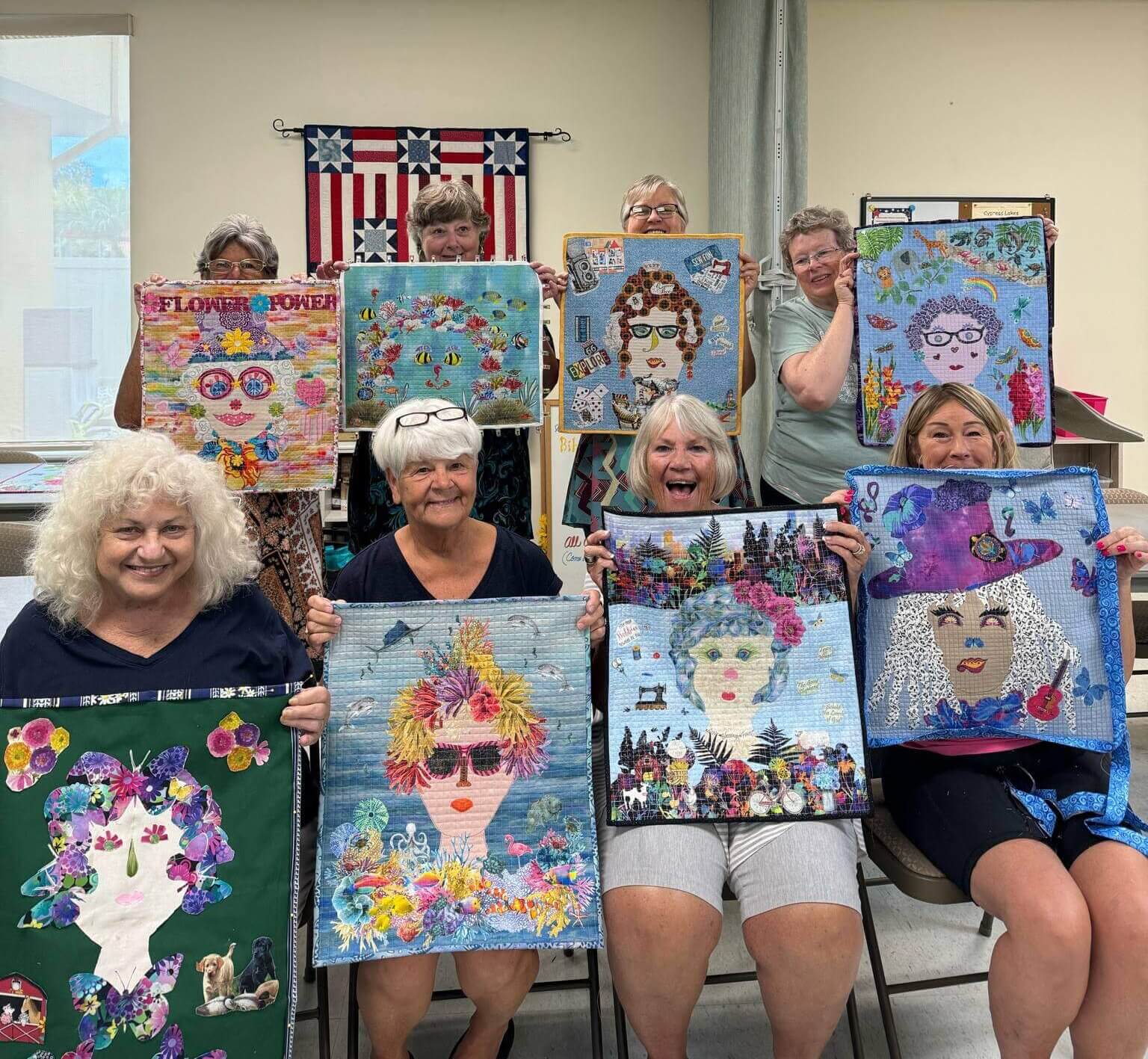 Residents at Cypress Lakes Village in Lakeland, FL. hold up their quilts during an art class.