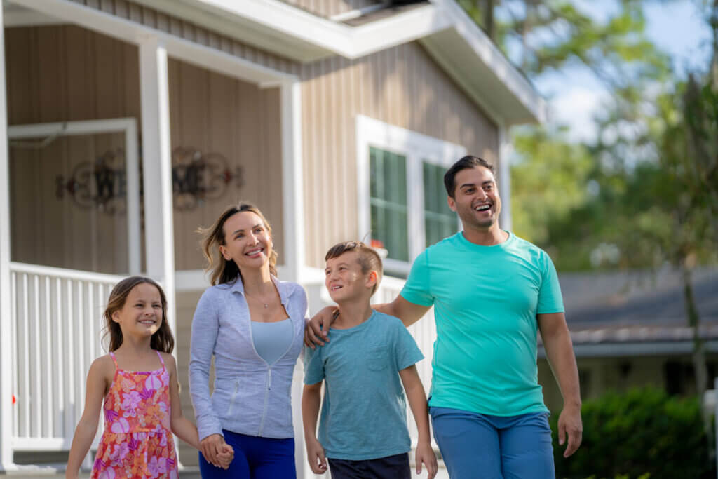 A family walking outside of a manufactured home.