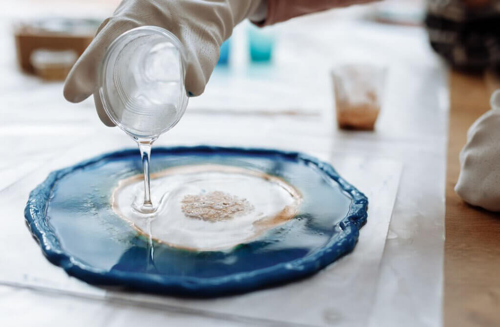 Hand in white glove pouring resin