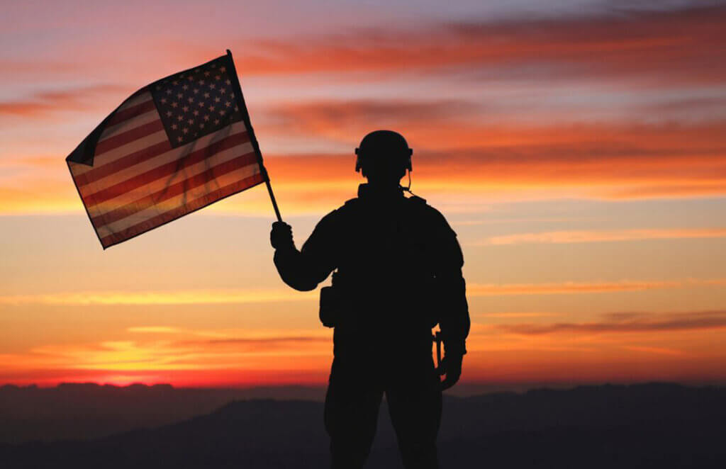 Soldier in the US Army in uniform holding the American Flag