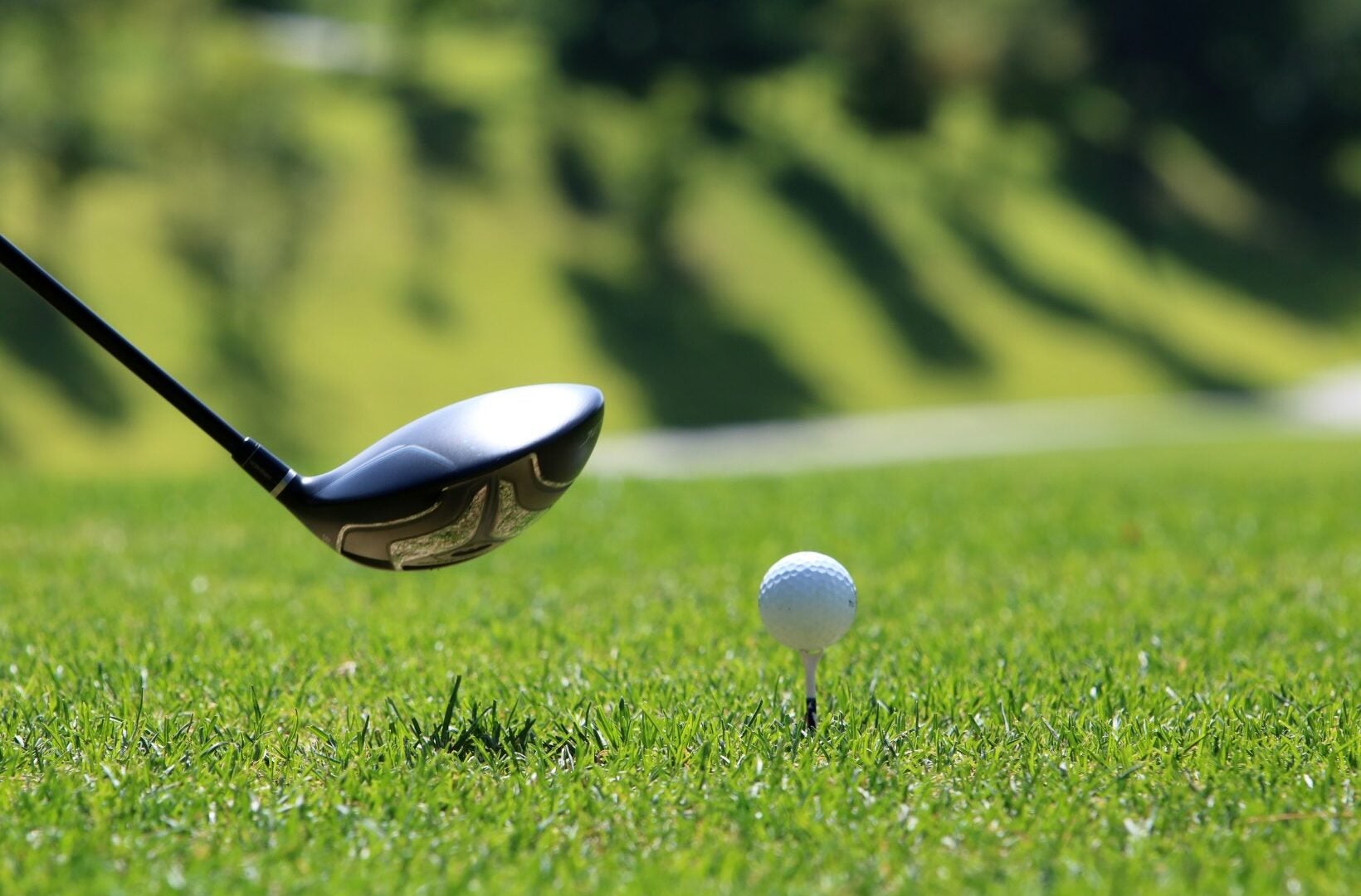 Golf ball on tee with club