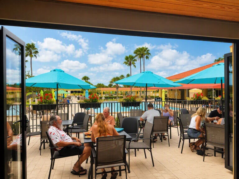 The patio at the newly renovated at Big Cypress Grill in Lakeland, Florida. People are sitting around tables with food and drink.