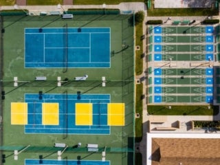 Birds eye view of the tennis, pickleball and shuffleboard courts at Camelot Lakes Village in Florida.