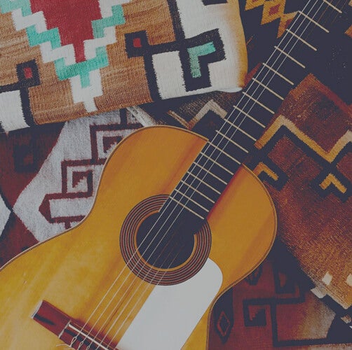 Spanish Guitar sitting on top of mexican inspired patterned blanket
