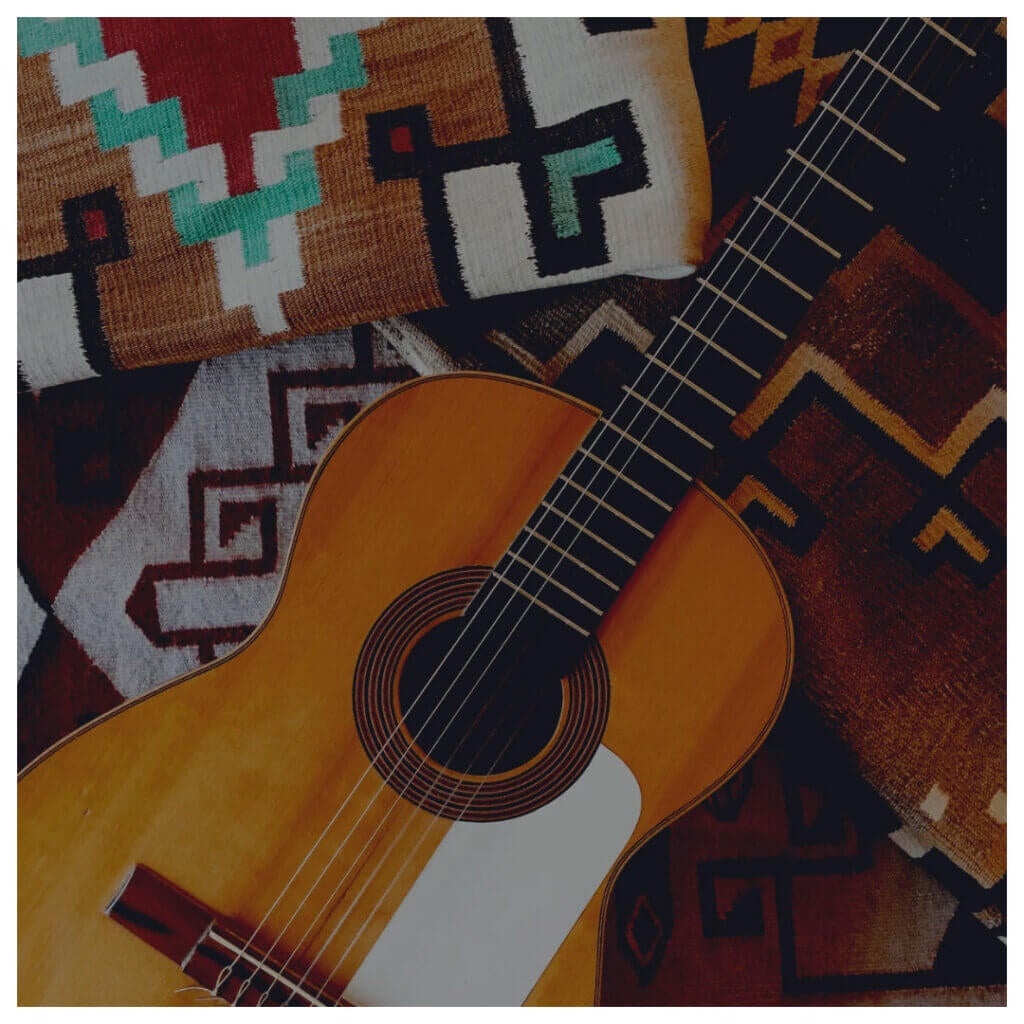 Spanish Guitar sitting on top of mexican inspired patterned blanket