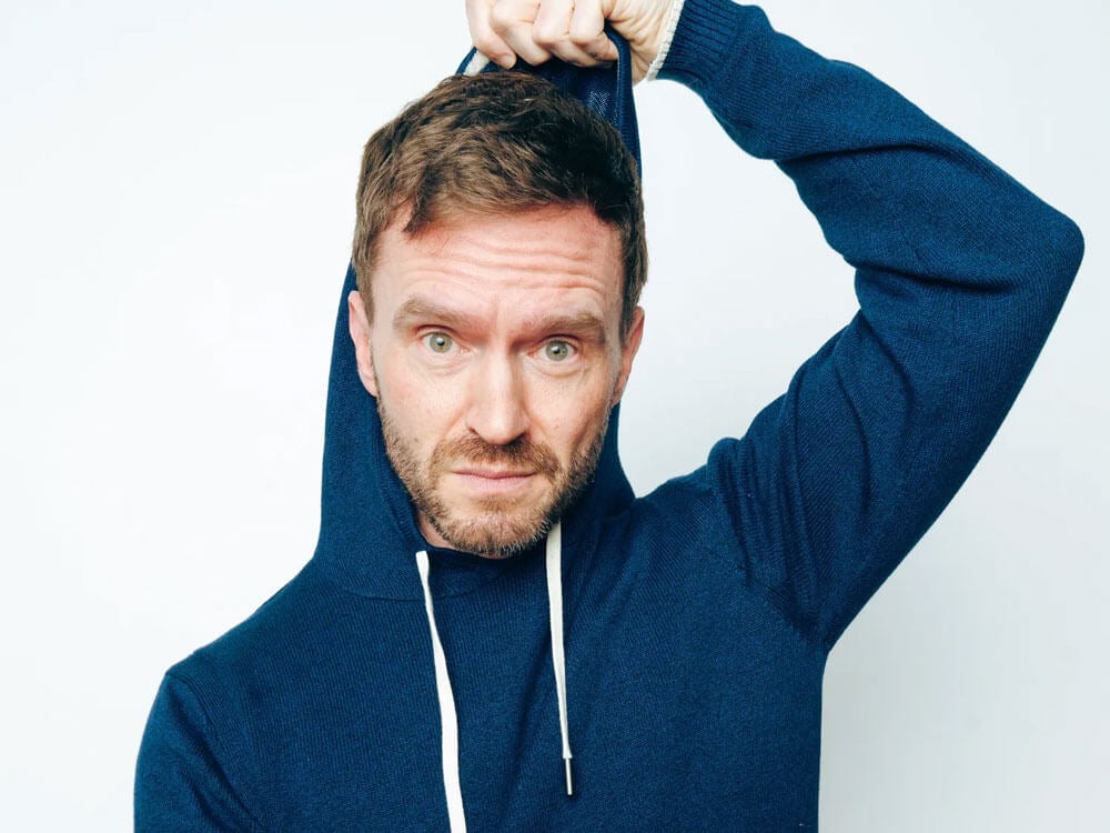 Comedian Tim McKeever wearing a hooded sweatshirt.