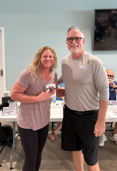 Community Manager and awards a resident a gift card at 55+ community, Rolling Greens Village in Ocala, Florida.