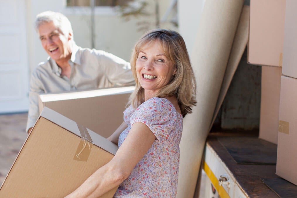 Couple carrying boxes from moving van