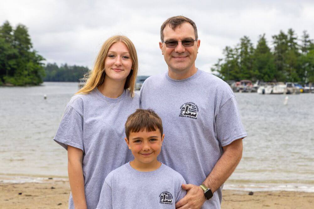 Family posing on the beach at Point Sebago Resort in Casco, Maine.