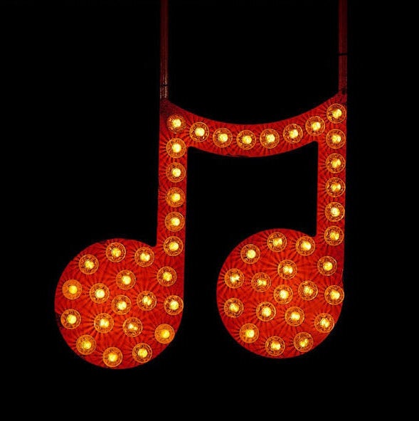 Red musical notes with bulb lights on an all black background