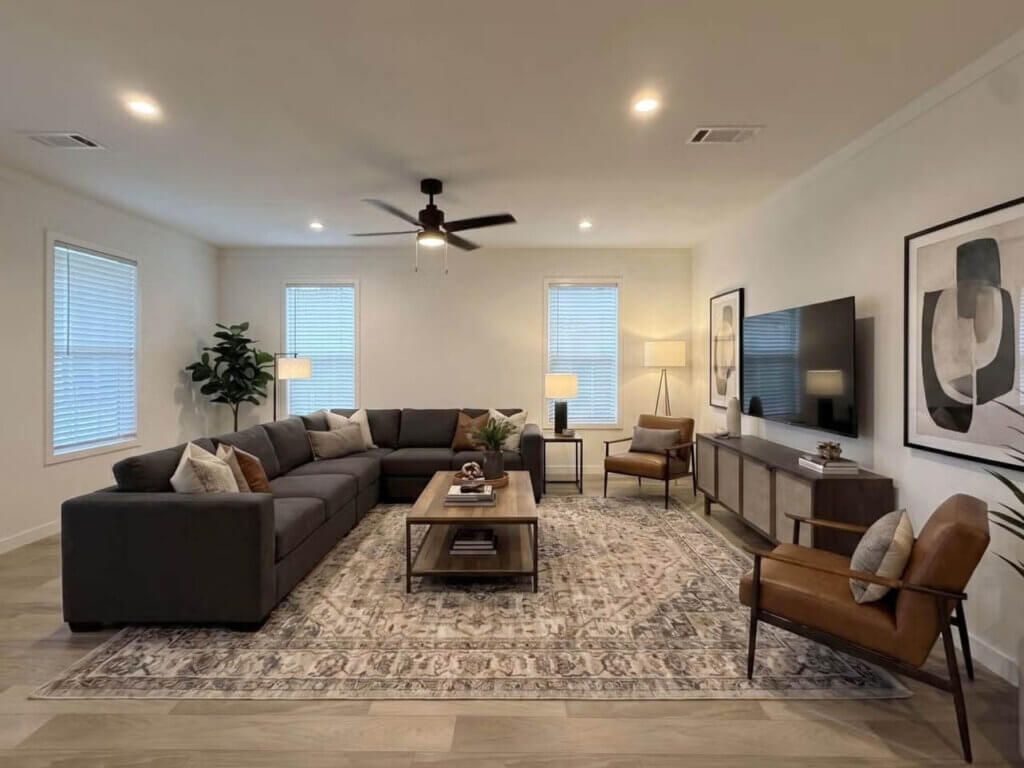A living room featuring a couch, coffee table, chairs, and a TV inside a Dunedin Village manufactured home.