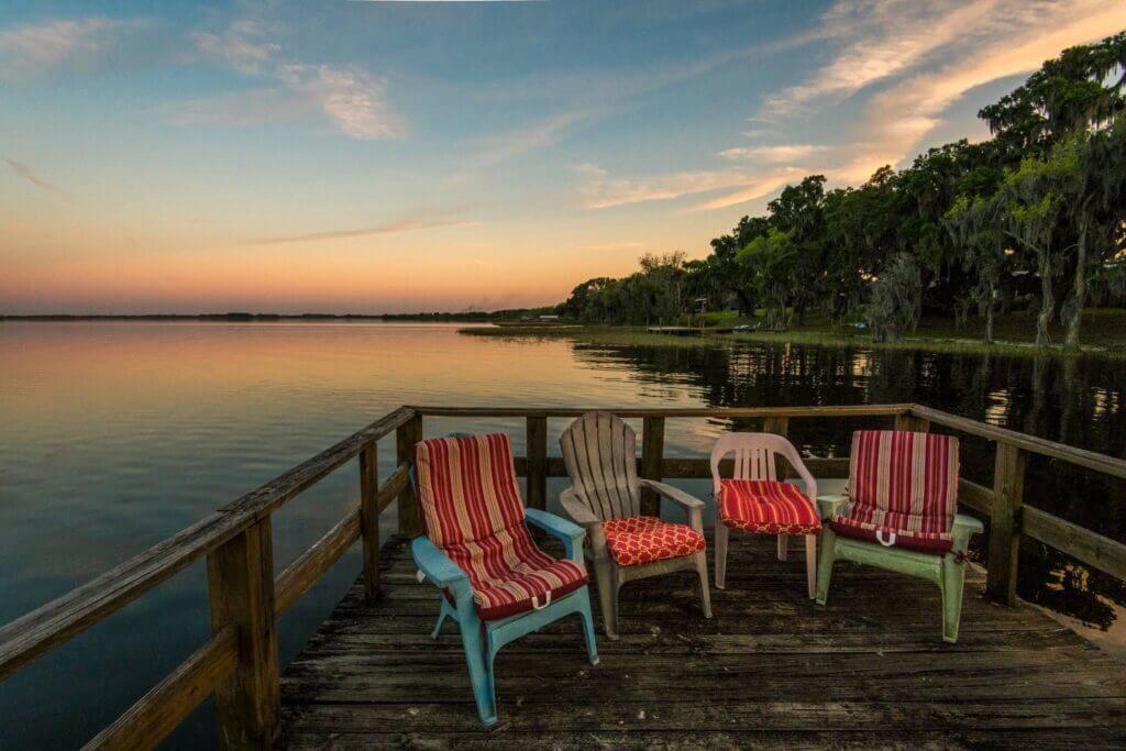 Dock with chairs with sunset over lake