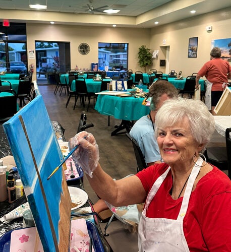 Resident painting in a guided painting class at The Meadows in Tarpon Springs, Florida.