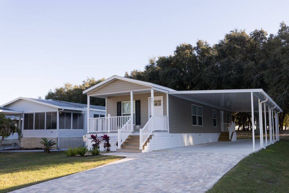 A park model manufactured home or sale with a carport and front porch at Oak Harbor RV Park in Florida.