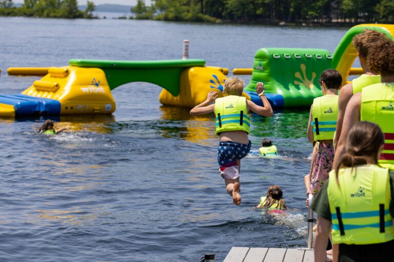 kid jumping in water next to waterpark