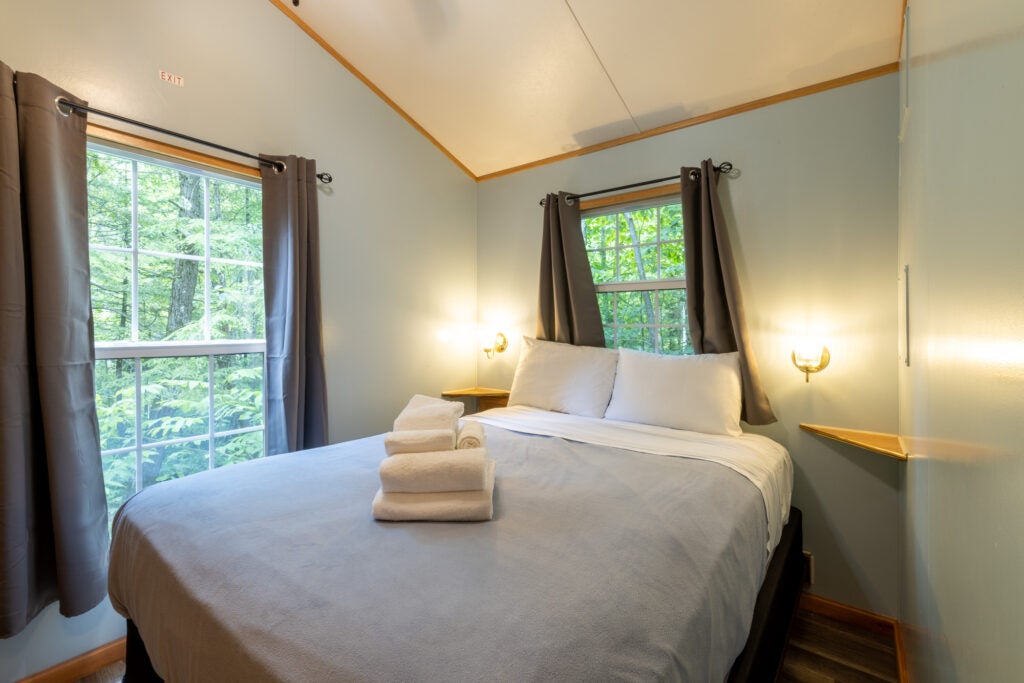 Master bedroom with double size bed with towels folded on bed.