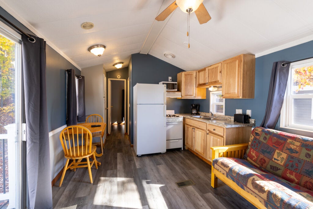 Kitchen with futon and dining table with two chairs.